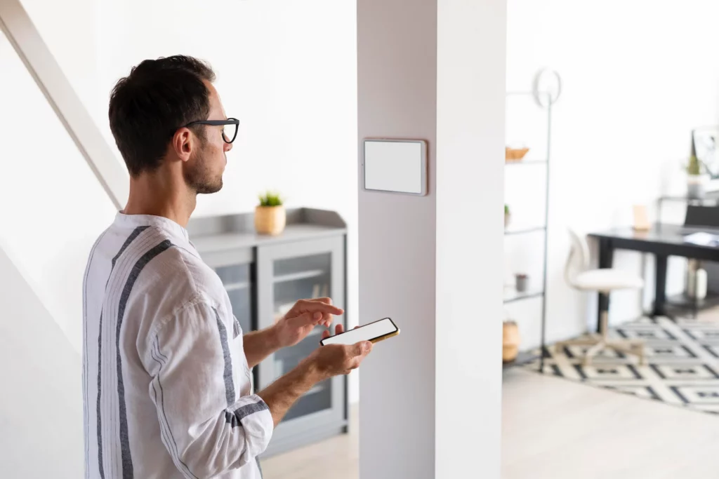 Homme qui utilise la domotique de sa maison.